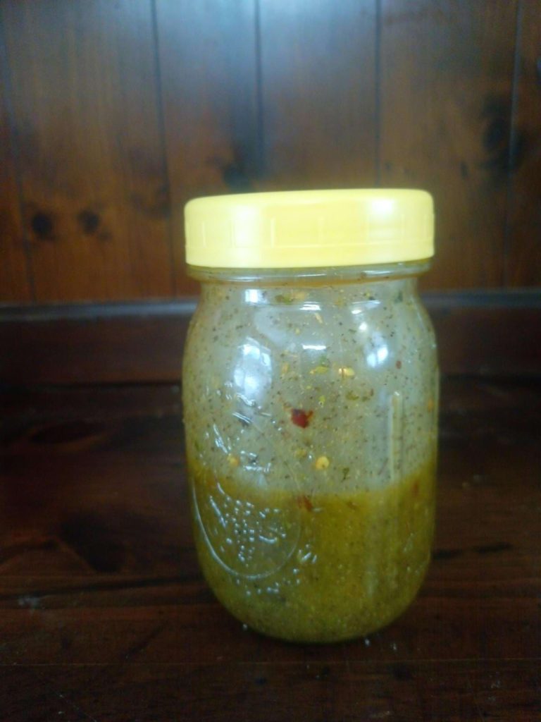 Homemade italian dressing in a mason jar with a yellow lid